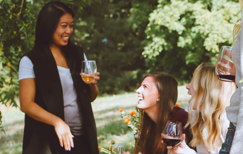 Talking with others about why you're not having children can feel invasive. Katie Wilson explains how she shares her childfree life choices (image: friends talking and laughing at a lawn party)